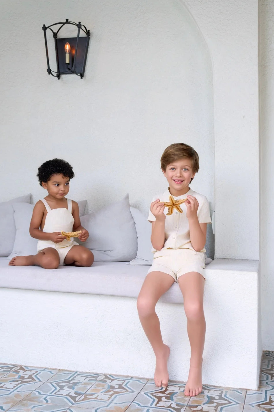 طقم ملابس عائلي متناسق للأولاد والبنات من مجموعة "AS SS26 meadow collection" باللون الأصفر الفاتح، فستان شموس بالورود للبنات وتطريز سموكنج للأولاد مخطط.