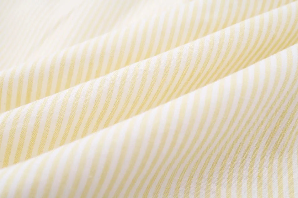 طقم ملابس عائلي متناسق للأولاد والبنات من مجموعة "AS SS26 meadow collection" باللون الأصفر الفاتح، فستان شموس بالورود للبنات وتطريز سموكنج للأولاد مخطط.