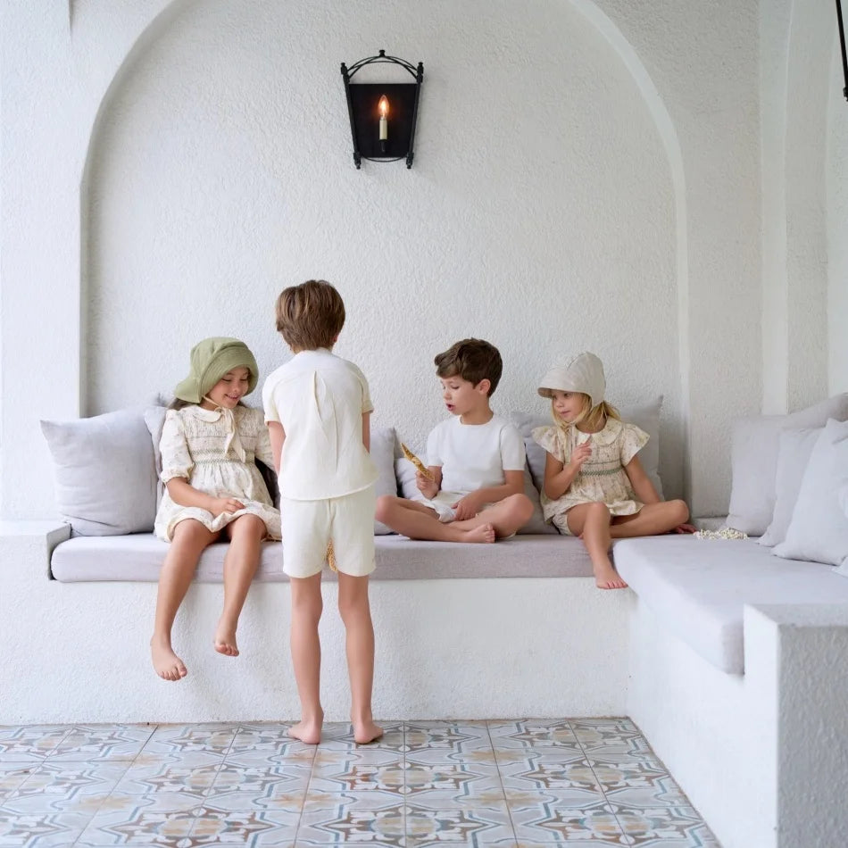 طقم ملابس عائلي متناسق للأولاد والبنات من مجموعة "AS SS26 meadow collection" باللون الأصفر الفاتح، فستان شموس بالورود للبنات وتطريز سموكنج للأولاد مخطط.
